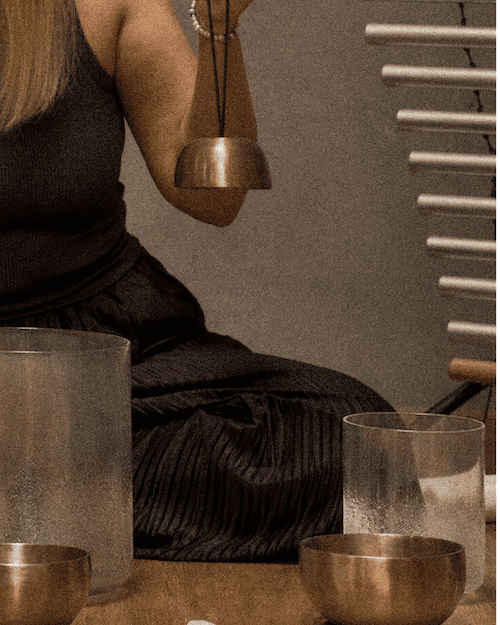 Lektorka s meditačními nástroji a kříšťálovými mísami na workshopu v jógovém studiu Yoga Movement. 