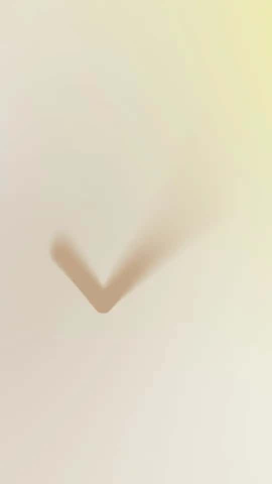 A blurred shade of beige with a checkmark shape in the shadow against a light background.