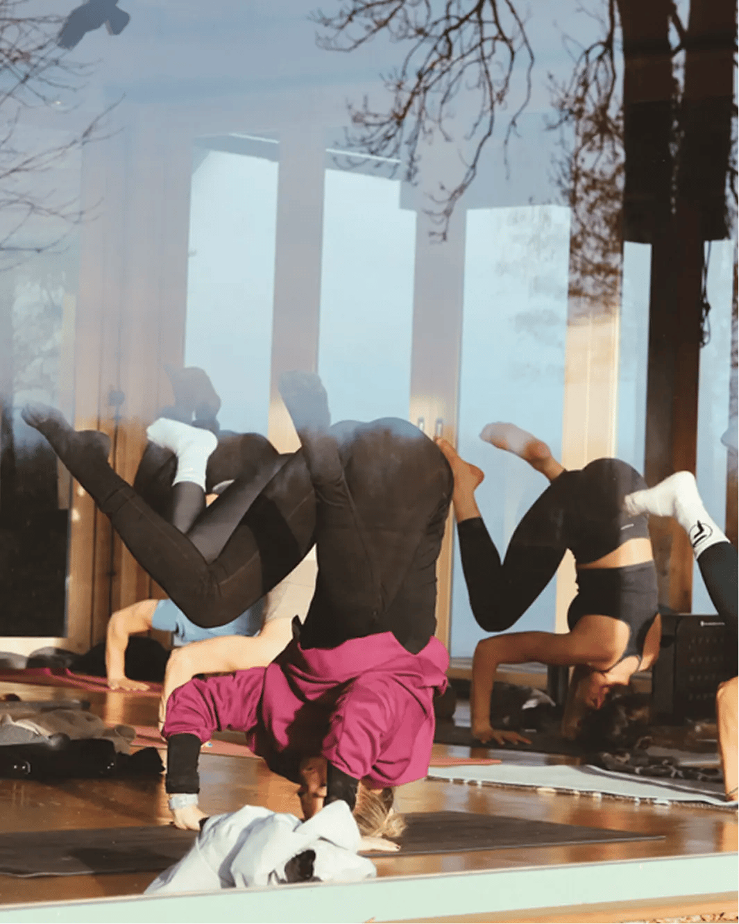 Účastníci jógového retreatu Yoga Movement cvičí pokročilé obrácené pozice v jógové šale