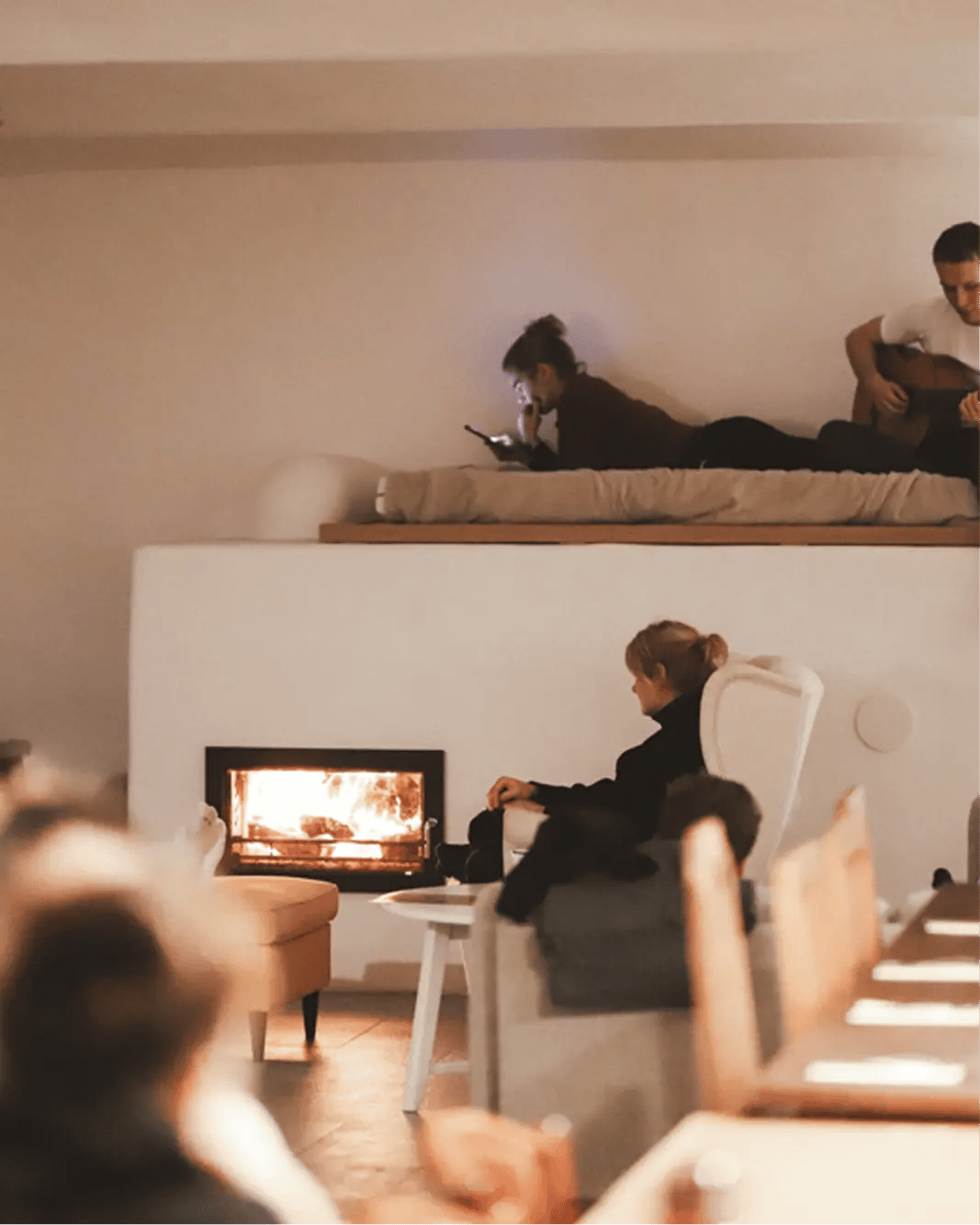 Útulná atmosféra u hořícího krbu během odpočinku na jógovém retreatu studia Yoga Movement.
